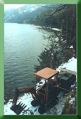 Kubota with compressor above lake on new trail.