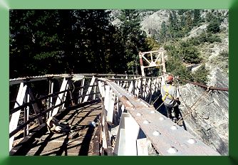 Looking down bridge centerline, showing bent top chord and Keith Monohan installing temporary suspenders.