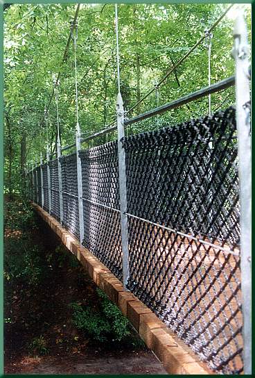 Railing and fence showing heavy cargo net, suspender bars, and horizontal tension cables.