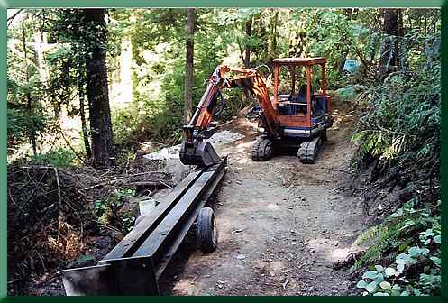 Trailering the tower legs over trail to the bridge site.